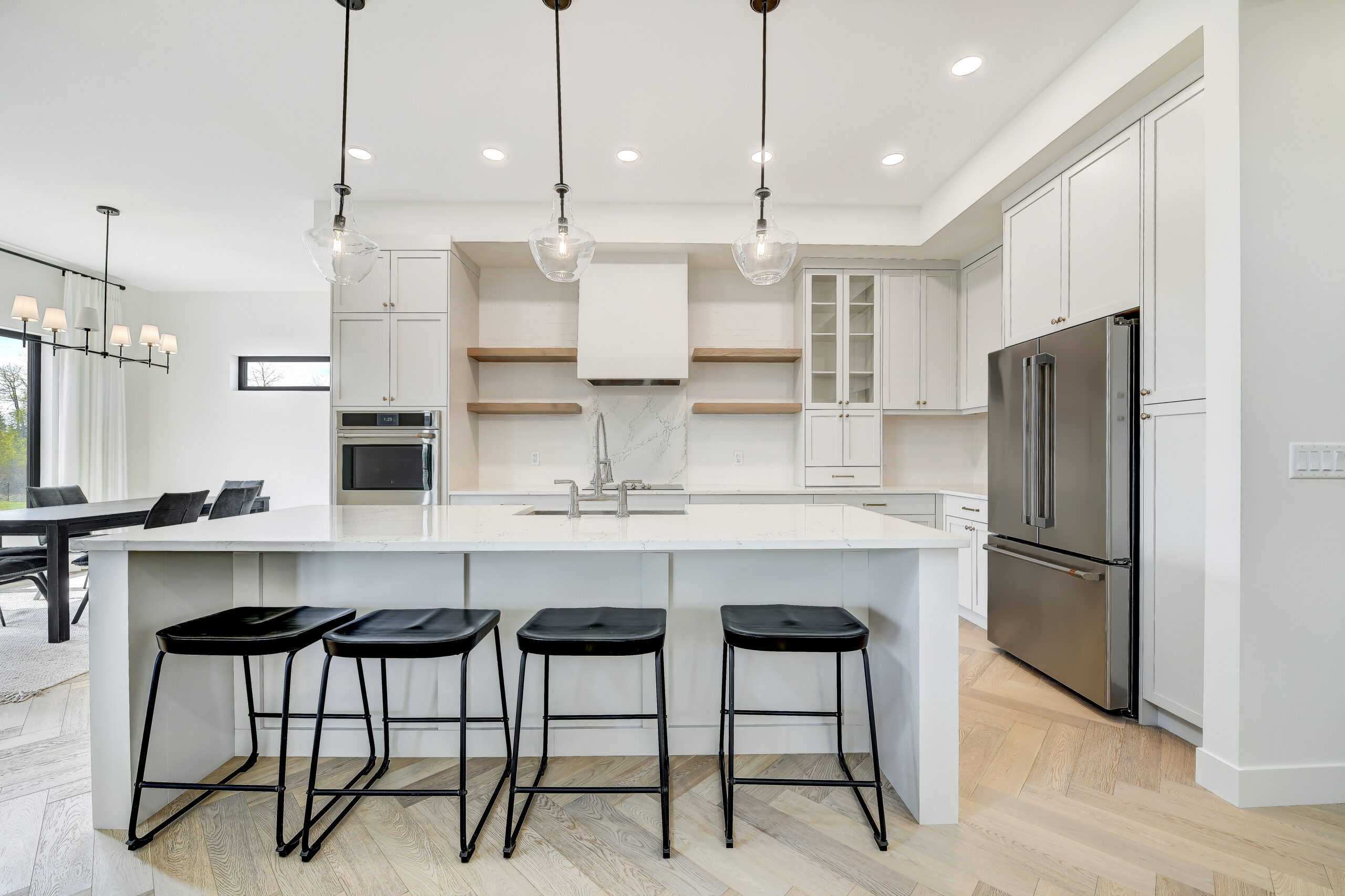 Grande Prairie home's kitchen with black stools and white counters